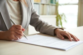 cropped-mid-section-unrecognizable-woman-signing-document